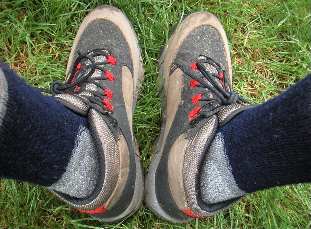 Hiking boots with merino socks on grass — best tramping socks NZ