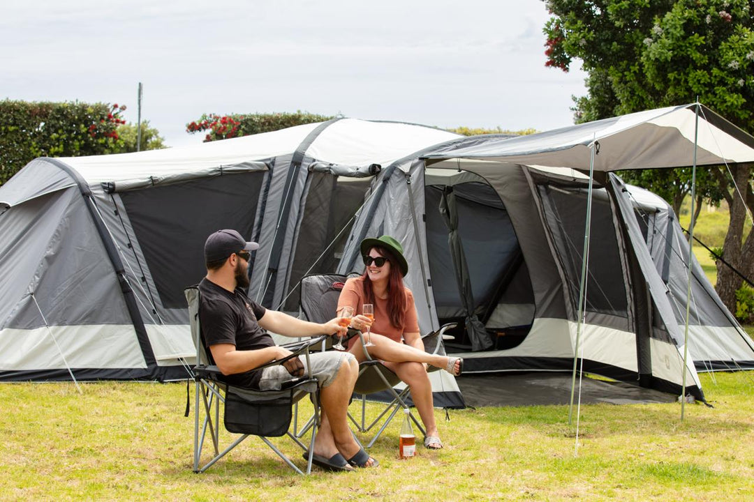 Couple relaxing in front of Dwights Enterprise inflatable tent at NZ campsite