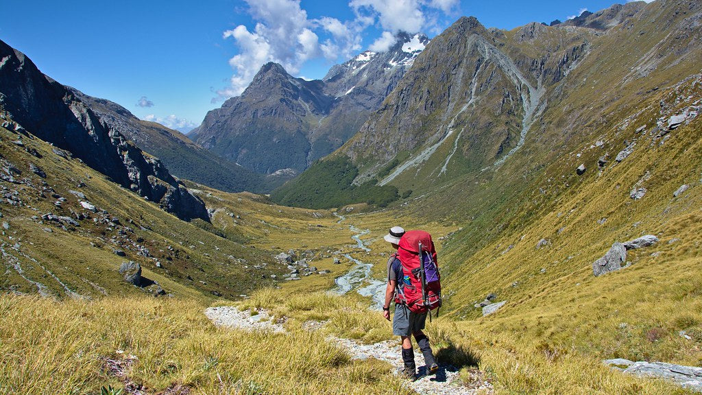 Backpacker on alpine trail — Best Base Layers NZ 2026