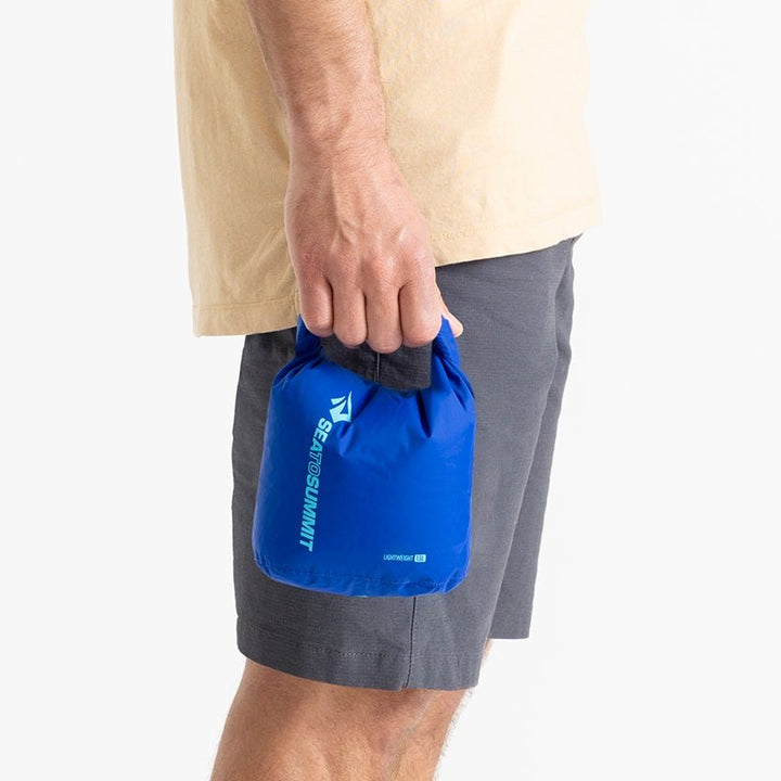 Sea to Summit Lightweight Dry Bag 1.5 litre in Surf Web Blue held in one hand to show its size.