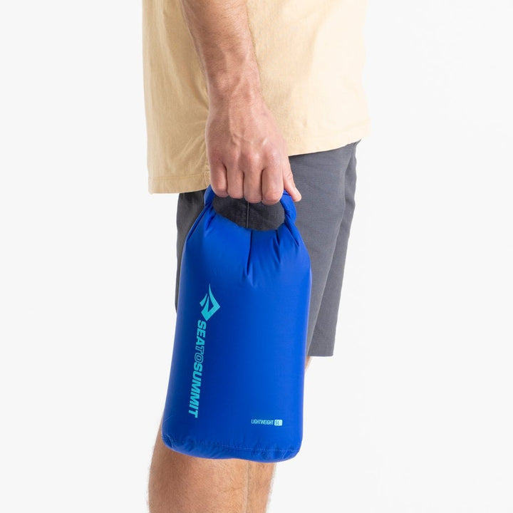 Sea to Summit Lightweight Dry Bag 5 litre in Surf Web Blue held in one hand to show its size.